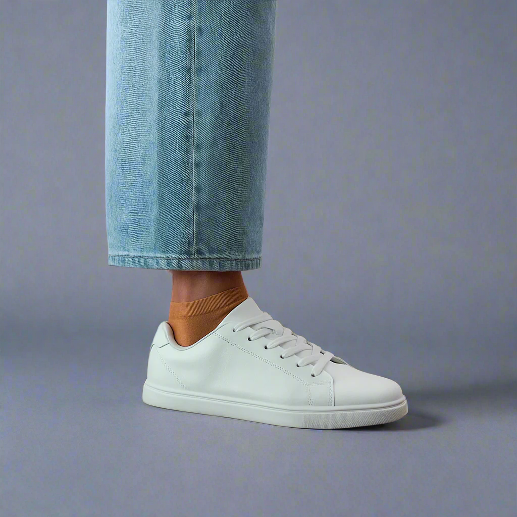 Sustainable Caramel color ankle socks made from lyocell, worn with white sneakers on wooden floor – Klue lookbook photo.