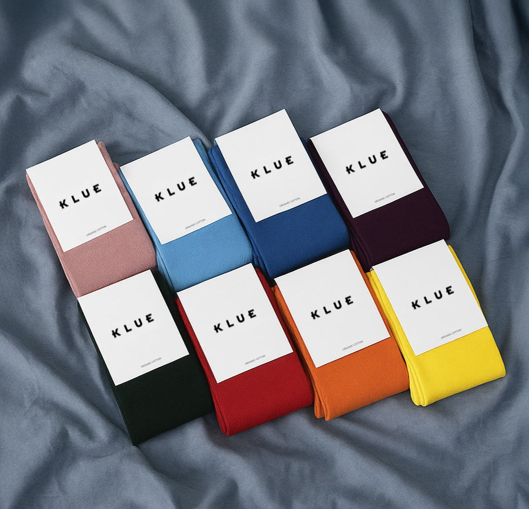 Set of KLUE socks in various colors on a textured surface