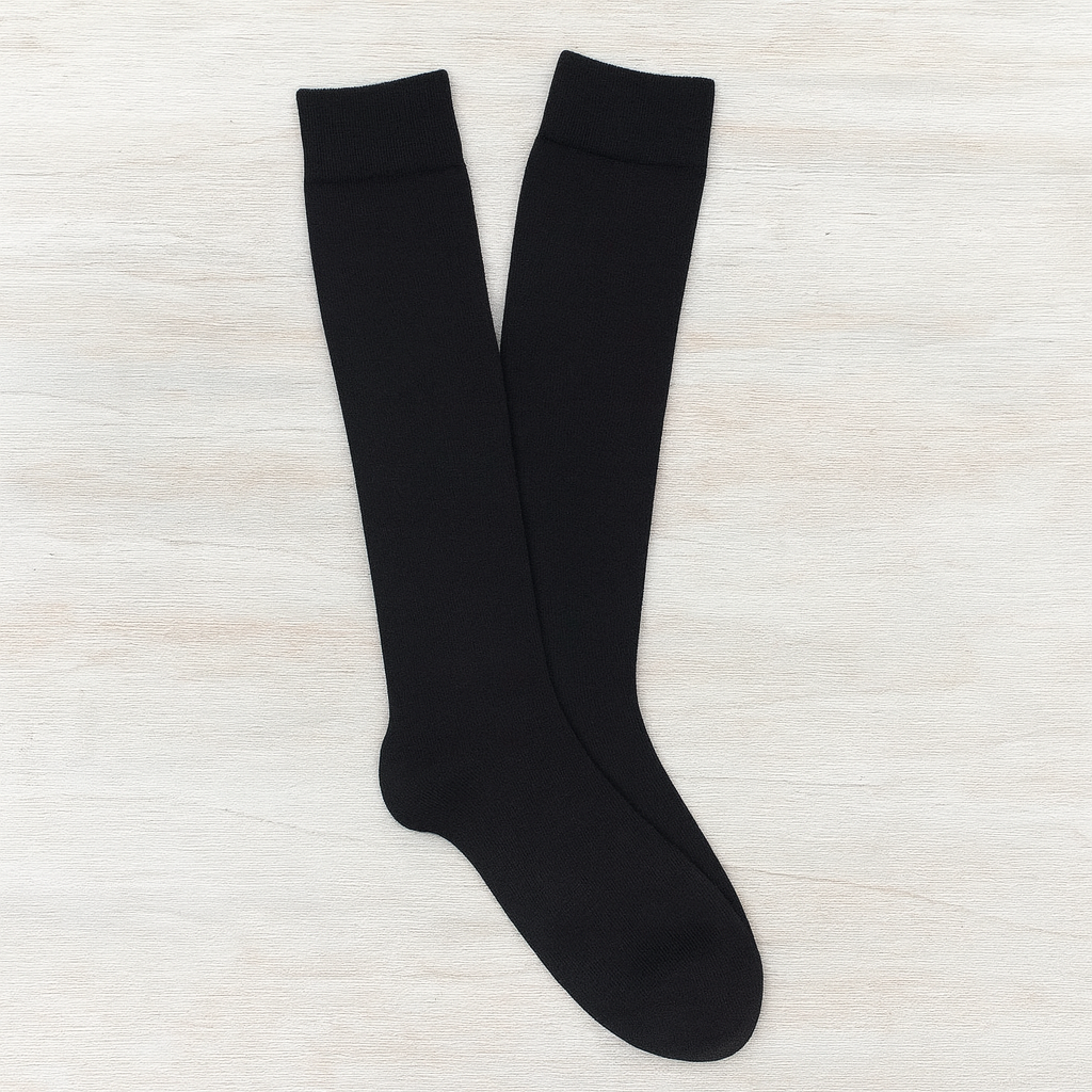 Pair of black knee-high socks on a light wooden surface