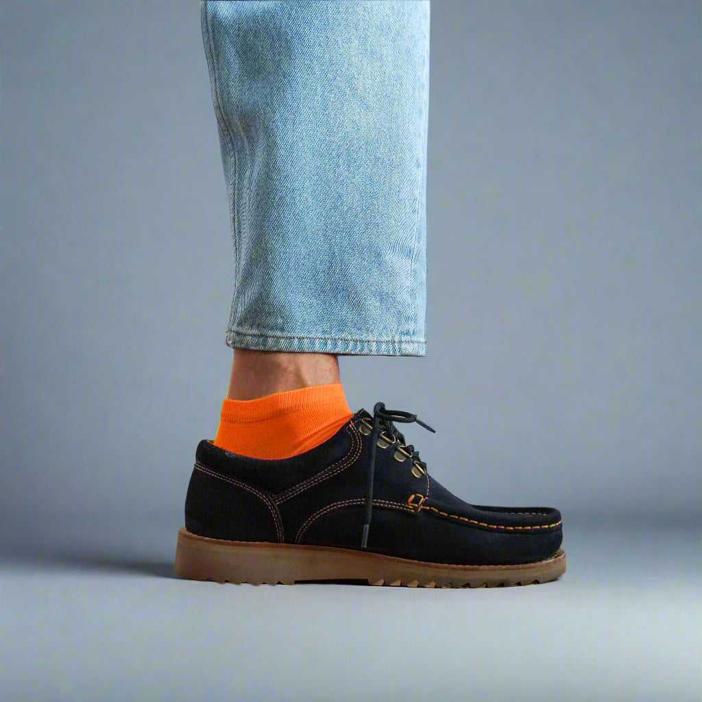 Sustainable orange ankle socks made from lyocell, worn with white sneakers on wooden floor – Klue lookbook photo