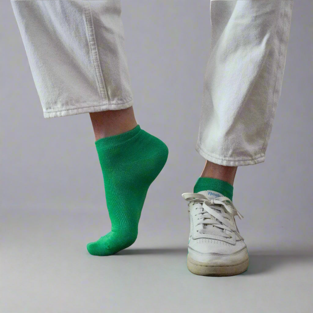Electric green sustainable ankle socks made from lyocell, worn with vintage sneakers and white denim – Klue bold eco fashion look.