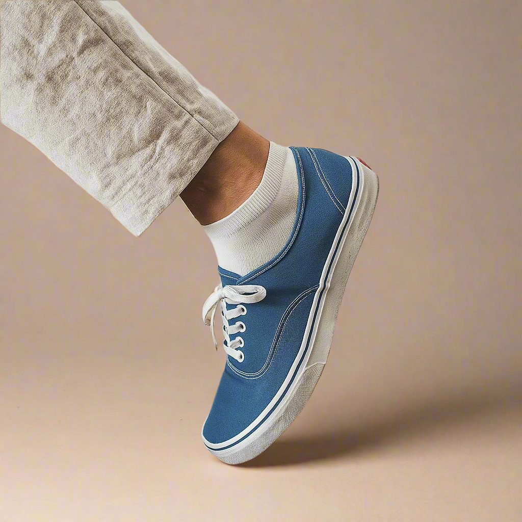 Sustainable white ankle socks made from lyocell, worn with white sneakers on wooden floor – Klue lookbook photo.
