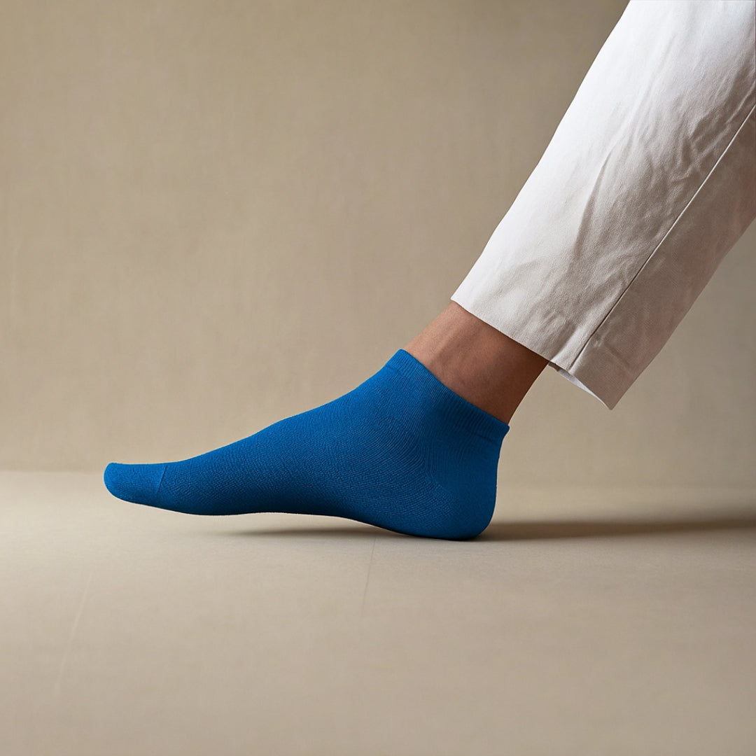 Sustainable blue ankle socks made from lyocell, worn with white sneakers on wooden floor – Klue lookbook photo.