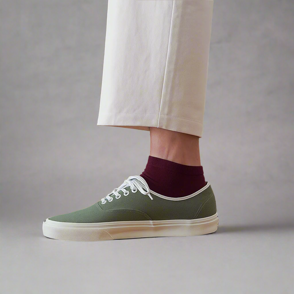 Sustainable burgundy wine ankle socks made from lyocell, worn with white sneakers on wooden floor – Klue lookbook photo.