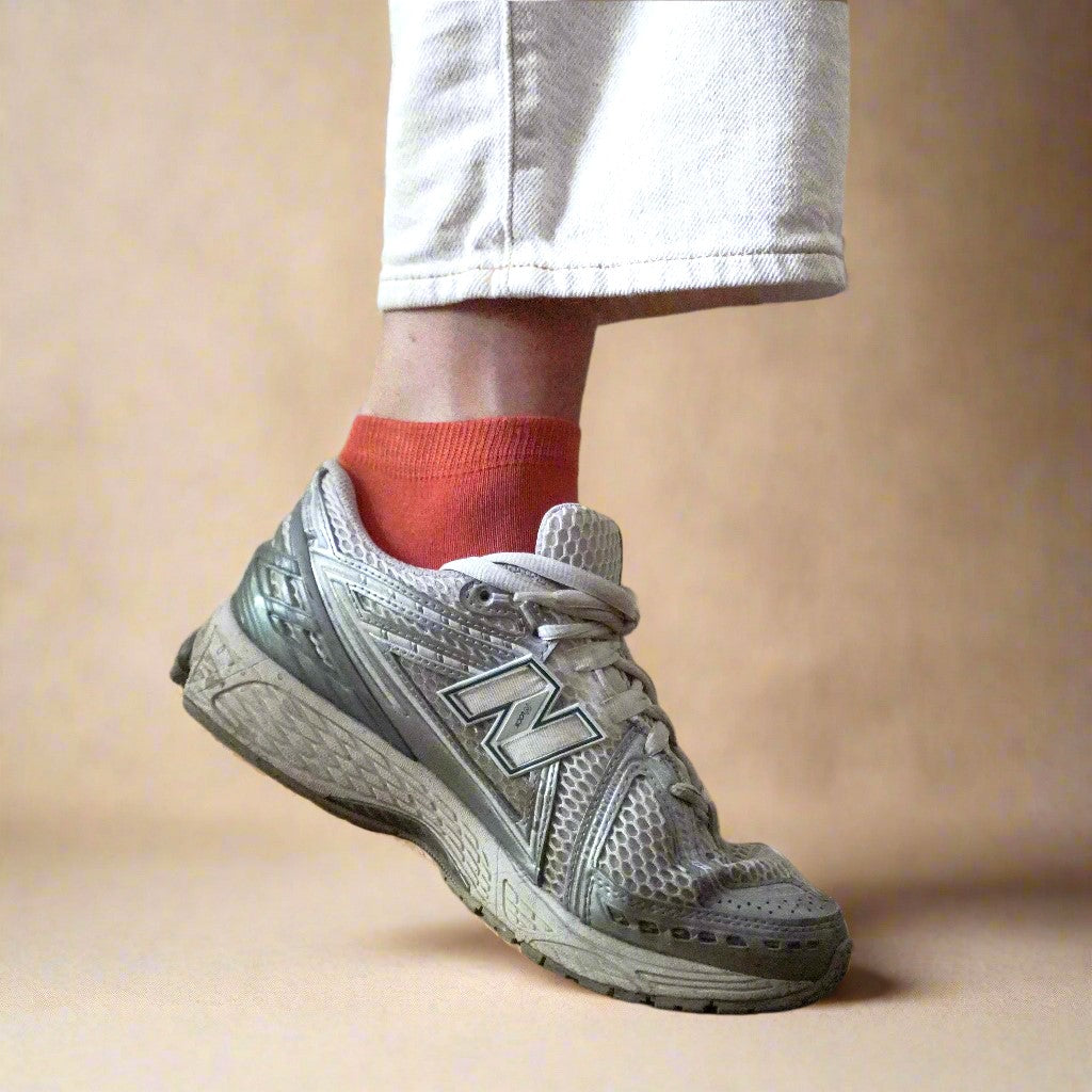 Women's terracotta lyocell low socks worn with white sneakers and neutral pants – Klue earthy sustainable socks style.