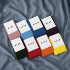 Set of KLUE socks in various colors on a textured surface